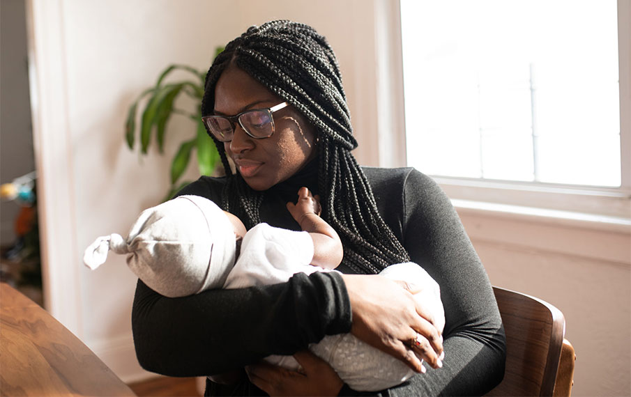 A black mother holding her infant.